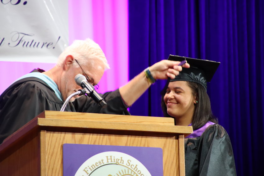 A speaker performs the ceremonial moving of the tassel on a student's graduation cap during the May 21 graduation ceremony at Colorado's Finest High School of Choice.